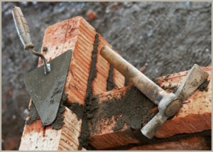 Tools laying on newly built brick wall.