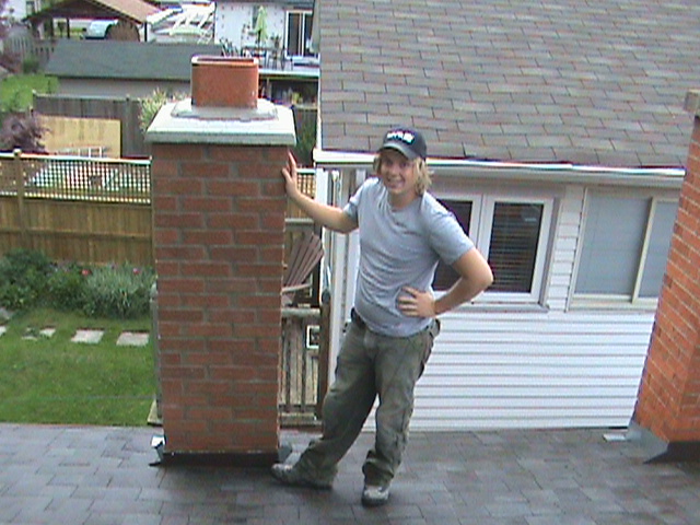 Clint Turnbull standing in front of repaired chimney.