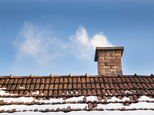 Chimney and snow on home.