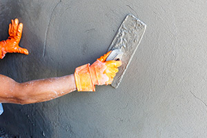 masonry worker repairing concrete wall.