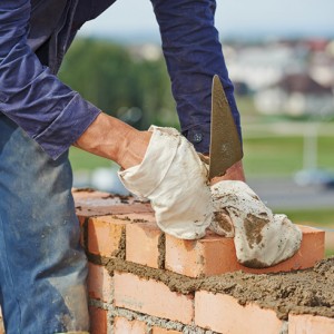 stone mason repairing brick wall.