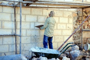Stone mason repairing the foundation of a building.