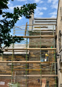 Historic Masonry Restoration. Masonry workers around historic building.