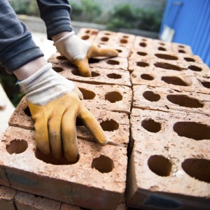 Bricklayer with brick at a construction site