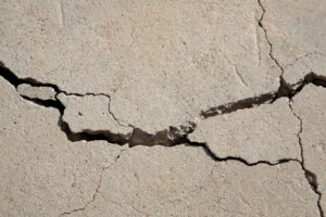 cracks in the concrete floor of a dilapitated building