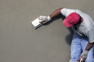 mason smoothing concrete on building
